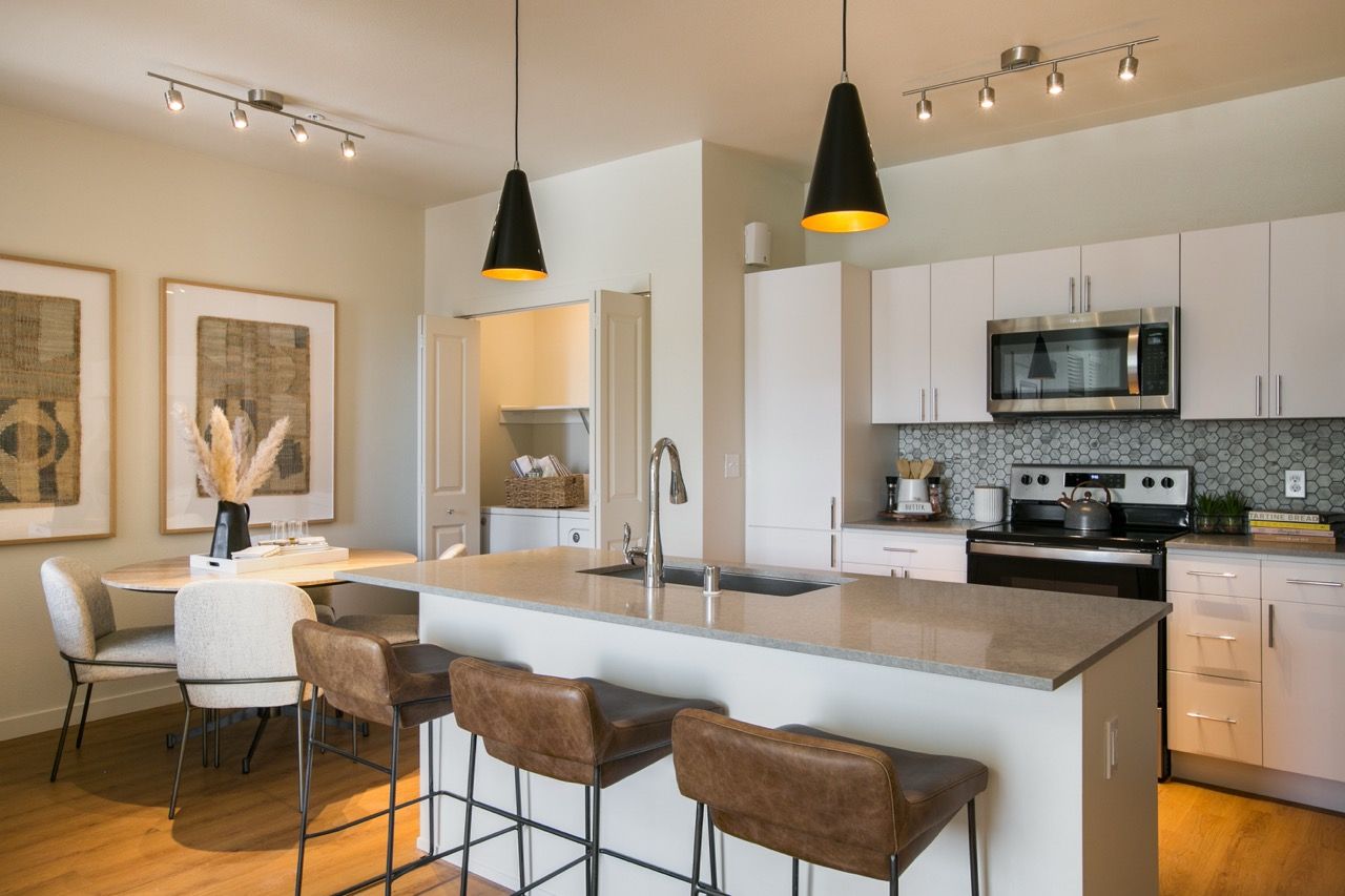 Open-concept kitchen with island, sink, and stainless-steel appliances.