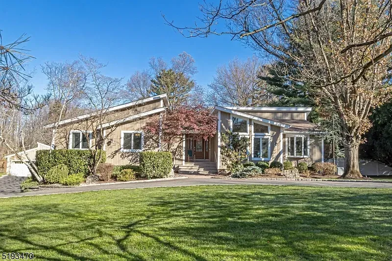 A large house with a lot of windows and a large lawn in front of it.