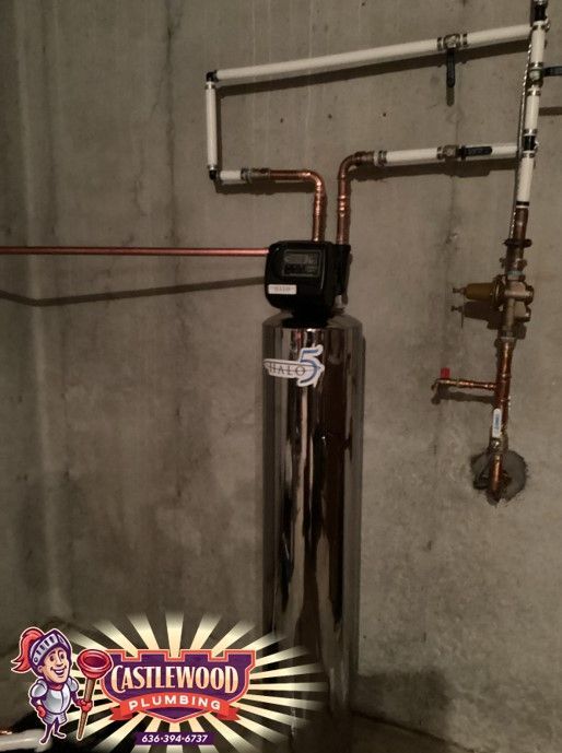 Chrome boiler tank with copper pipes and wall-mounted plumbing in a basement utility room