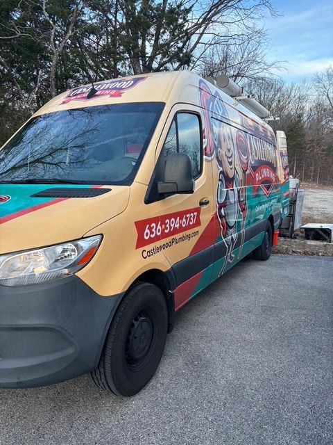 Colorful branded van parked outdoors on a roadside, with winter trees in the background.