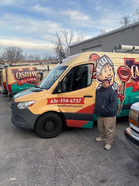 Food truck with cartoon chef mural and a man standing beside it in a parking lot.