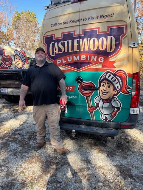 Man standing beside a Castlewood Plumbing truck with colorful logo and cartoon plumber graphic.