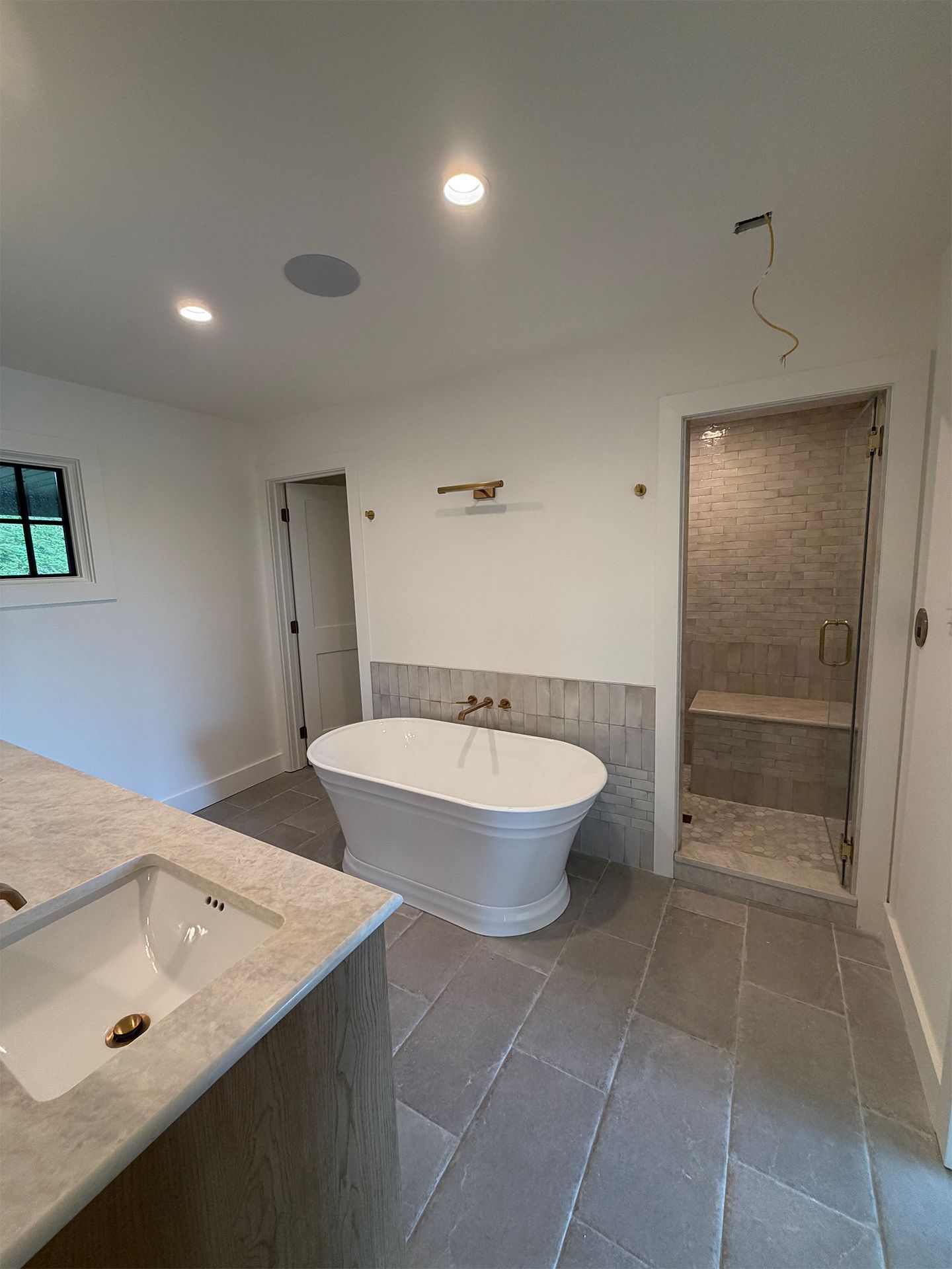 Modern bathroom with freestanding tub, tiled floor, vanity, and shower stall