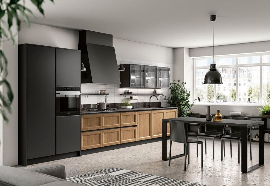 Cucina moderna con mobili neri e in legno, elettrodomestici in acciaio inossidabile e tavolo da pranzo.