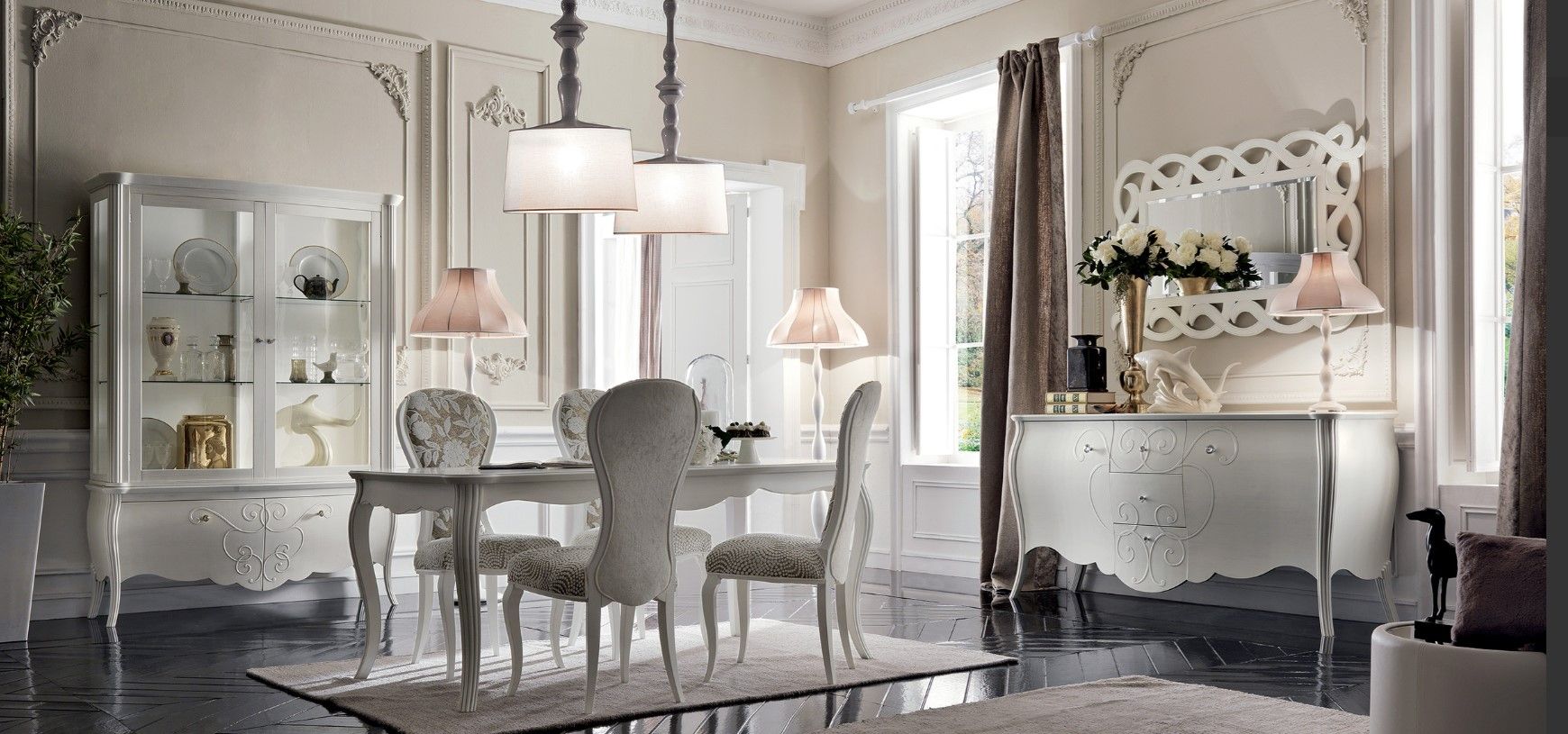Elegante sala da pranzo con mobili bianchi, finiture decorative e lampadario.