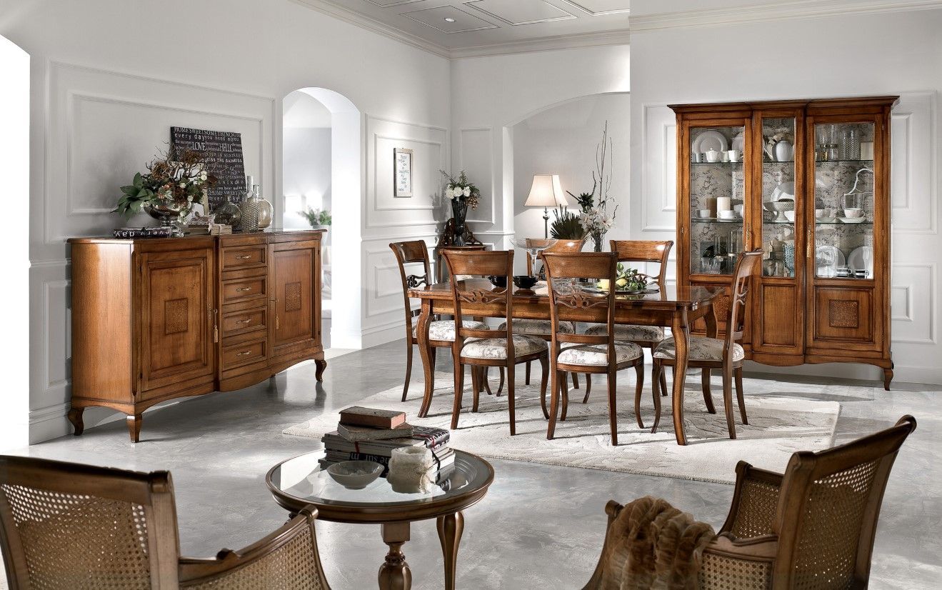 Sala da pranzo con mobili in legno: tavolo, sedie, credenza, buffet, poltrone e tavolino rotondo.