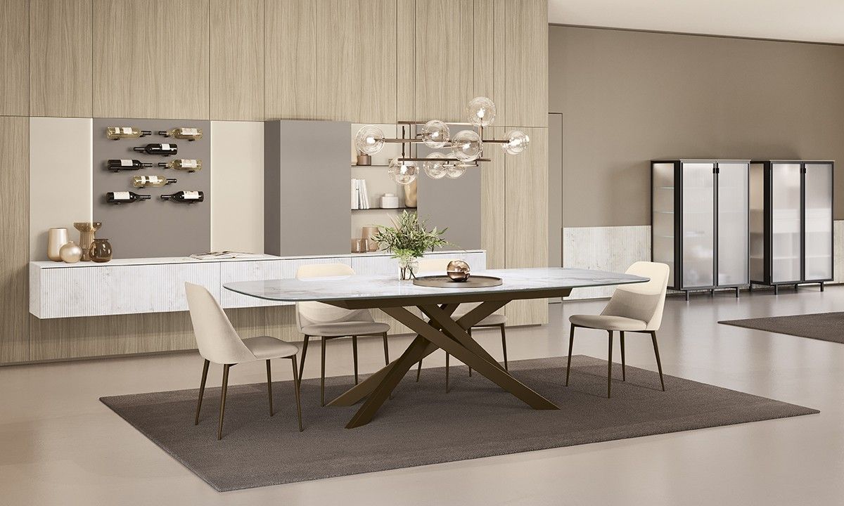 Cucina bianca e luminosa con piano di lavoro grigio e un vaso di fiori gialli.