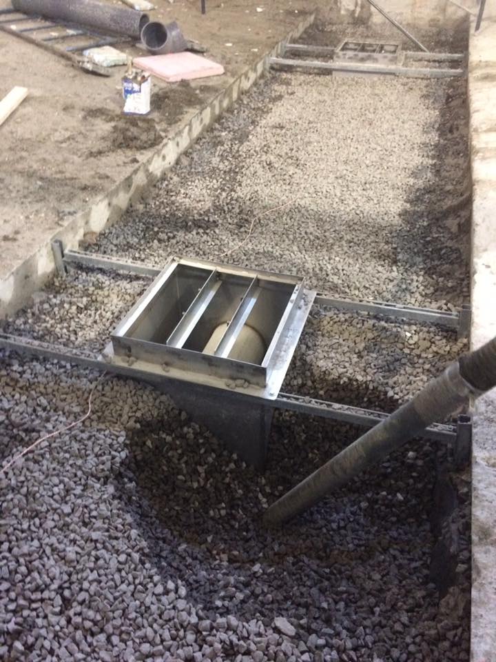 Une personne verse du béton dans un trou dans le sol.