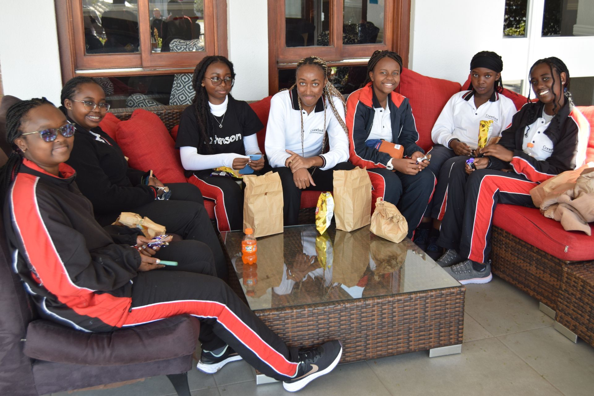 A group of young women are sitting on a couch.