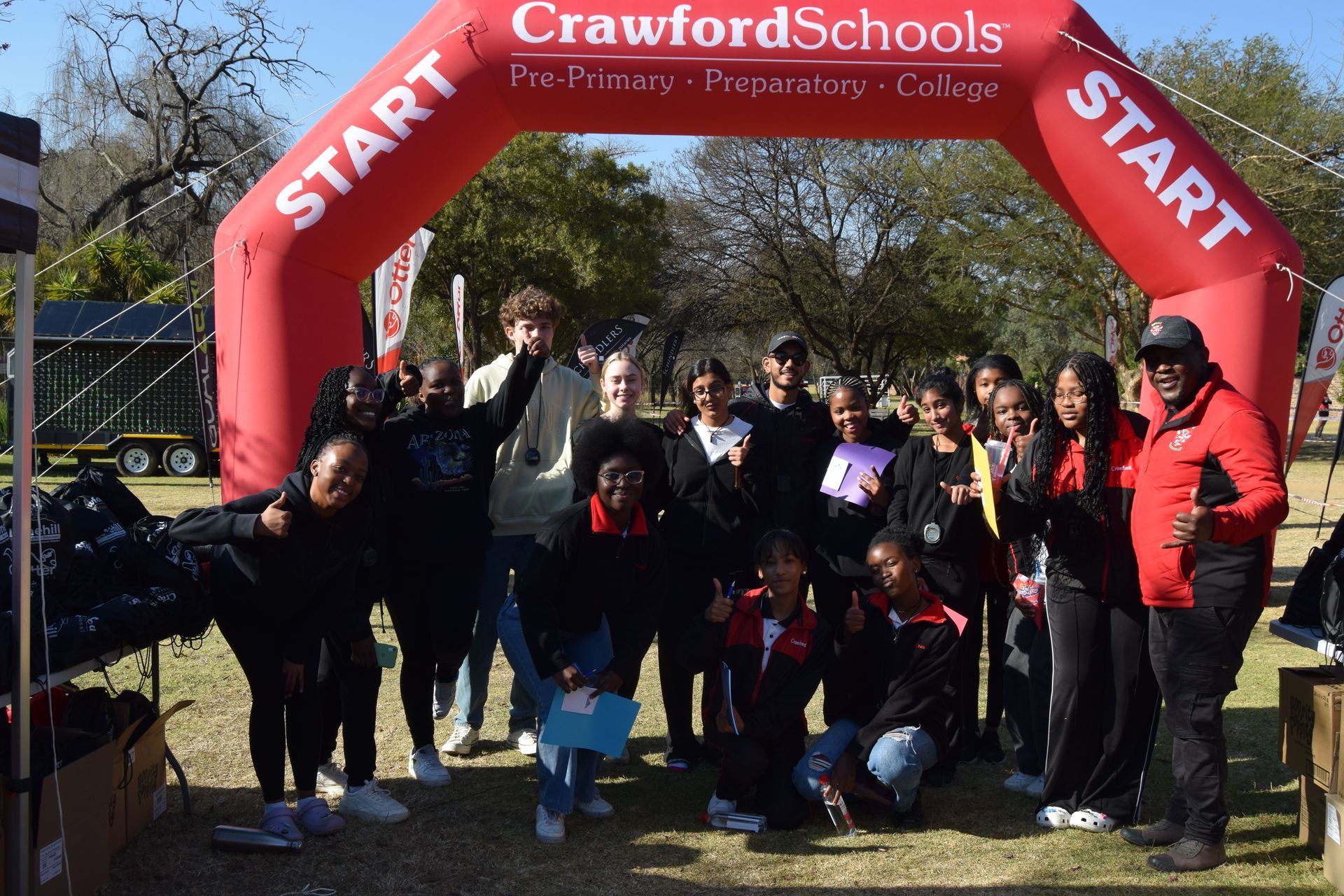 A group of people standing in front of a red start sign