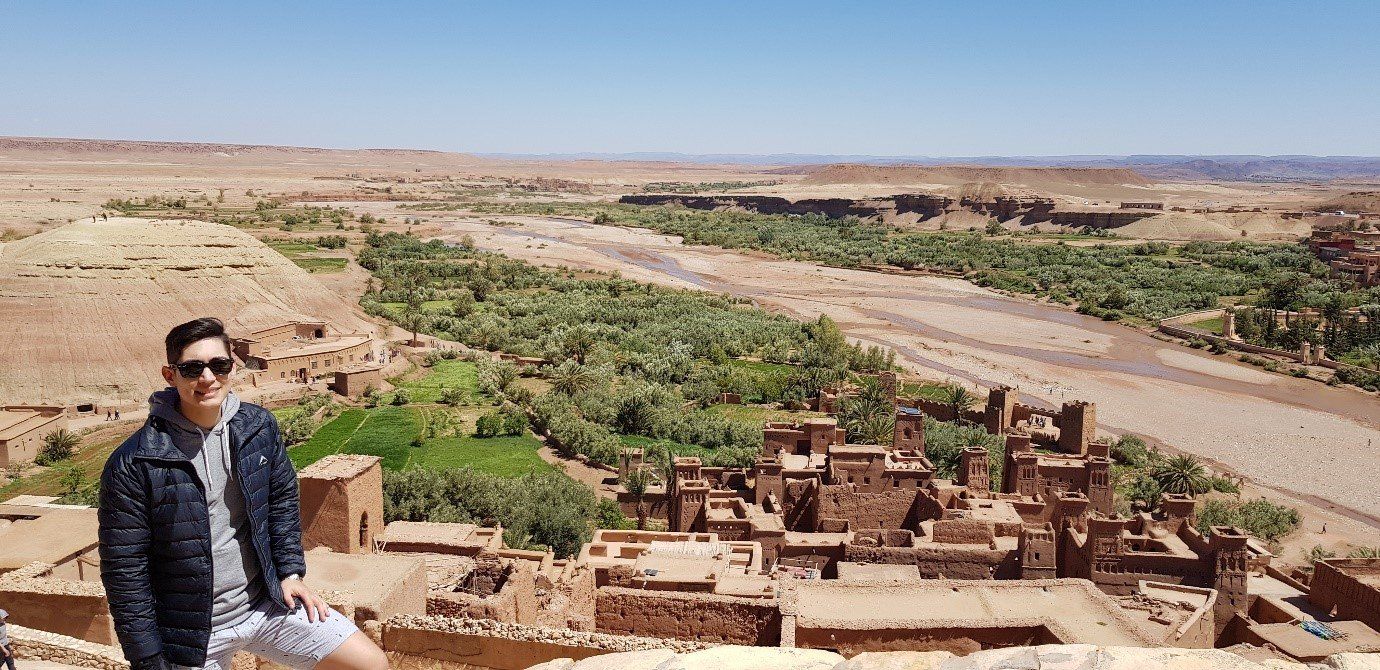 A man is standing on top of a hill overlooking a valley.