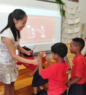A woman is teaching a group of children in a classroom.