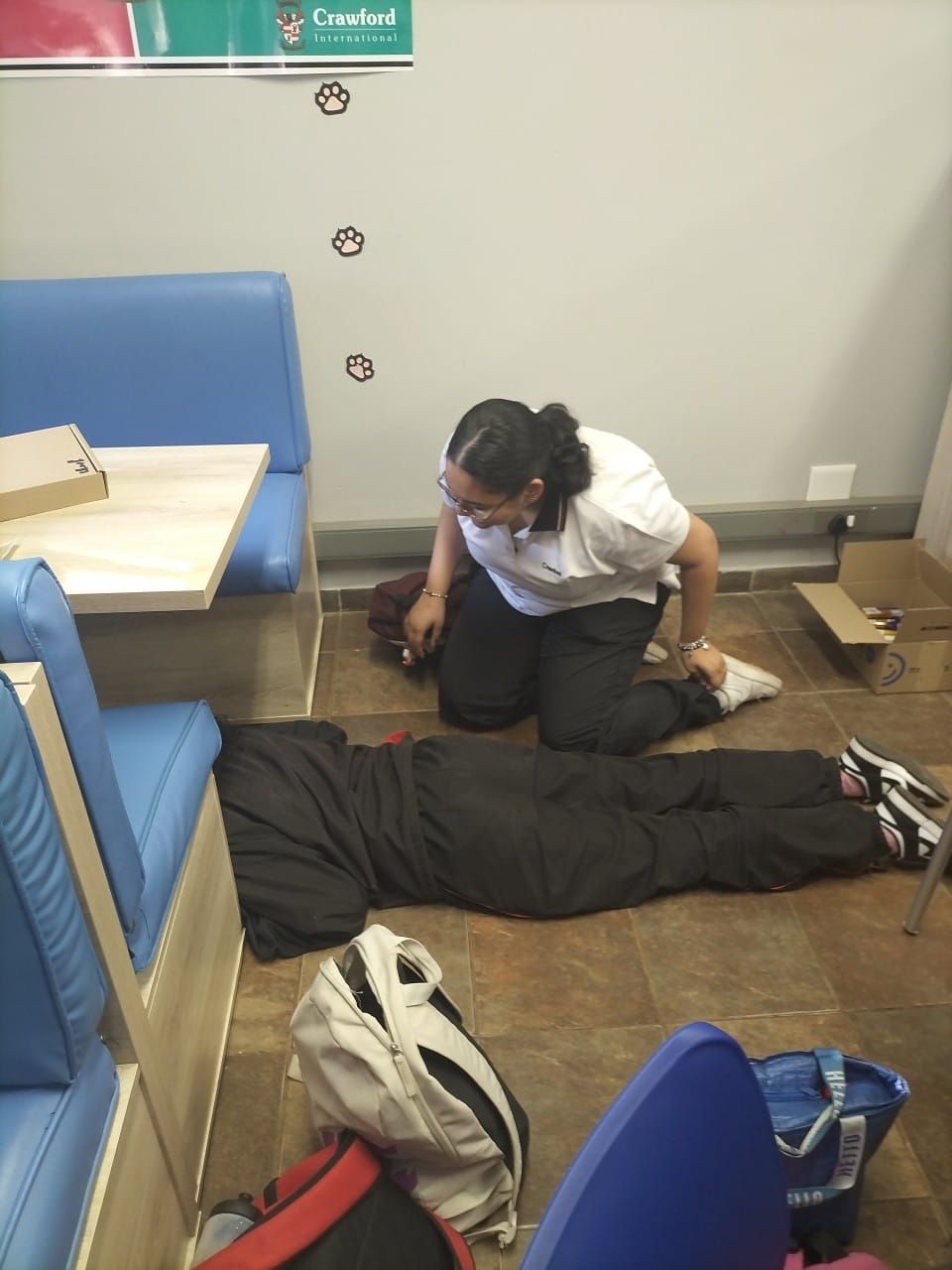 A woman is helping a man who is laying on the floor