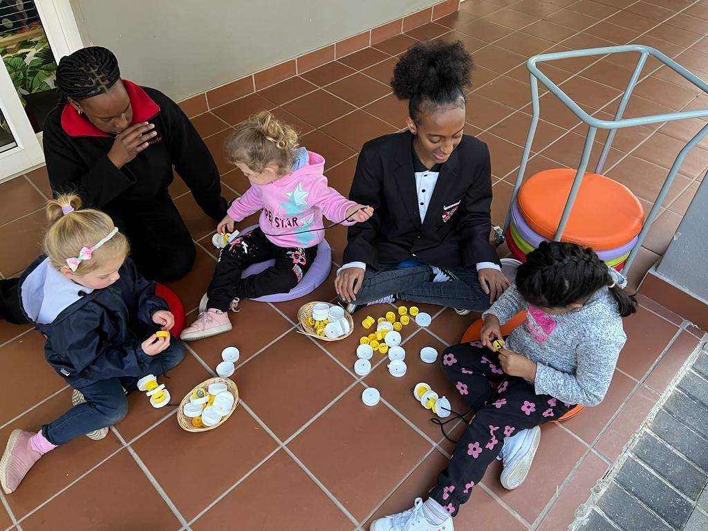 A group of children are sitting on the floor playing with eggs.