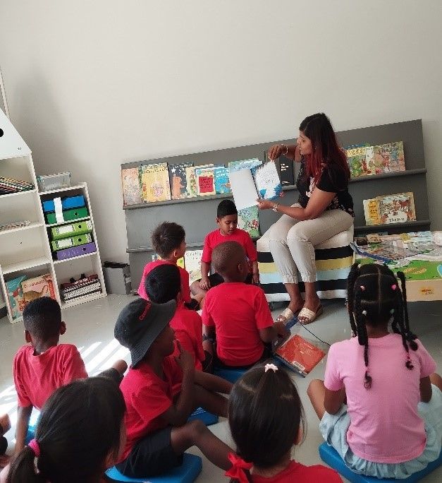 A woman is reading a book to a group of children.