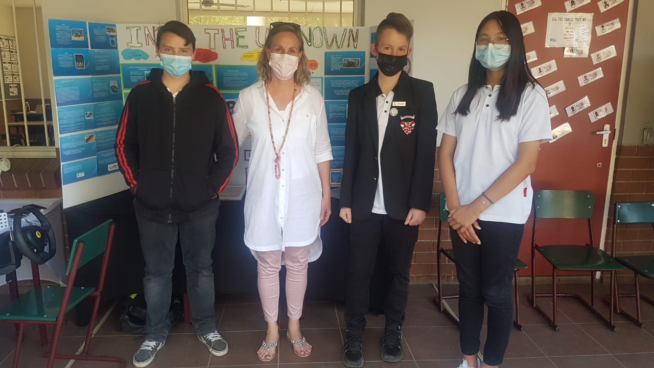 A group of people wearing face masks are standing next to each other in a room.