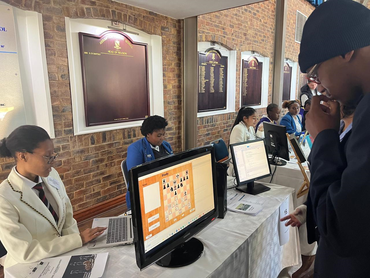 A group of people are sitting at a table with computers.