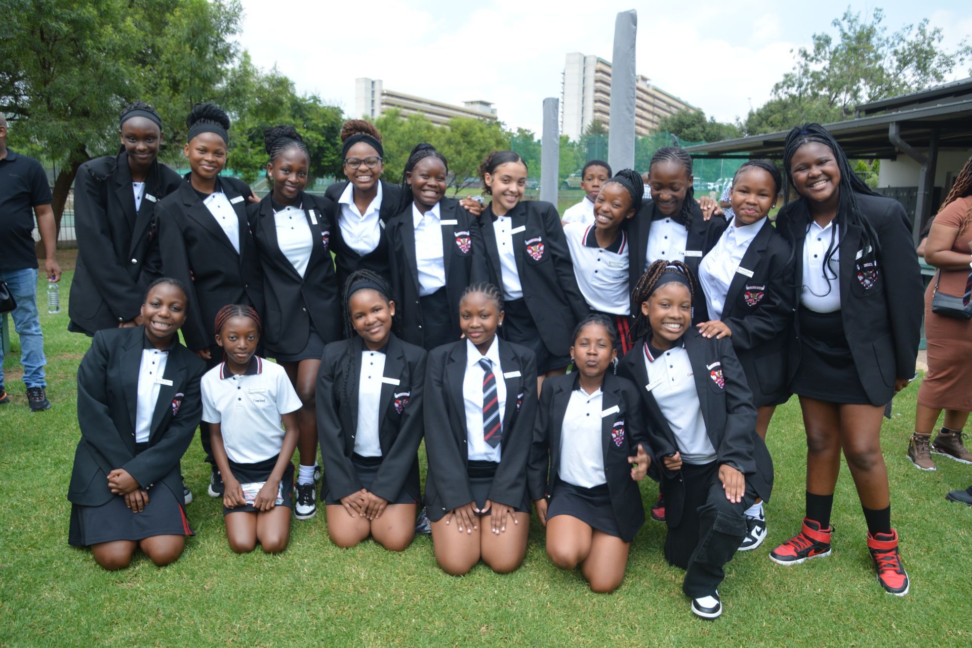 A group of young girls in school uniforms are posing for a picture.