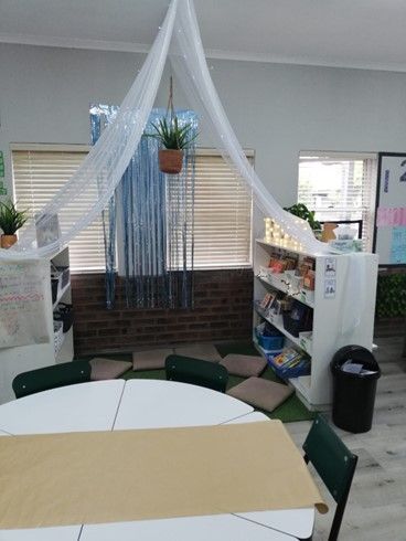 A classroom with a table and chairs and a canopy over the table.