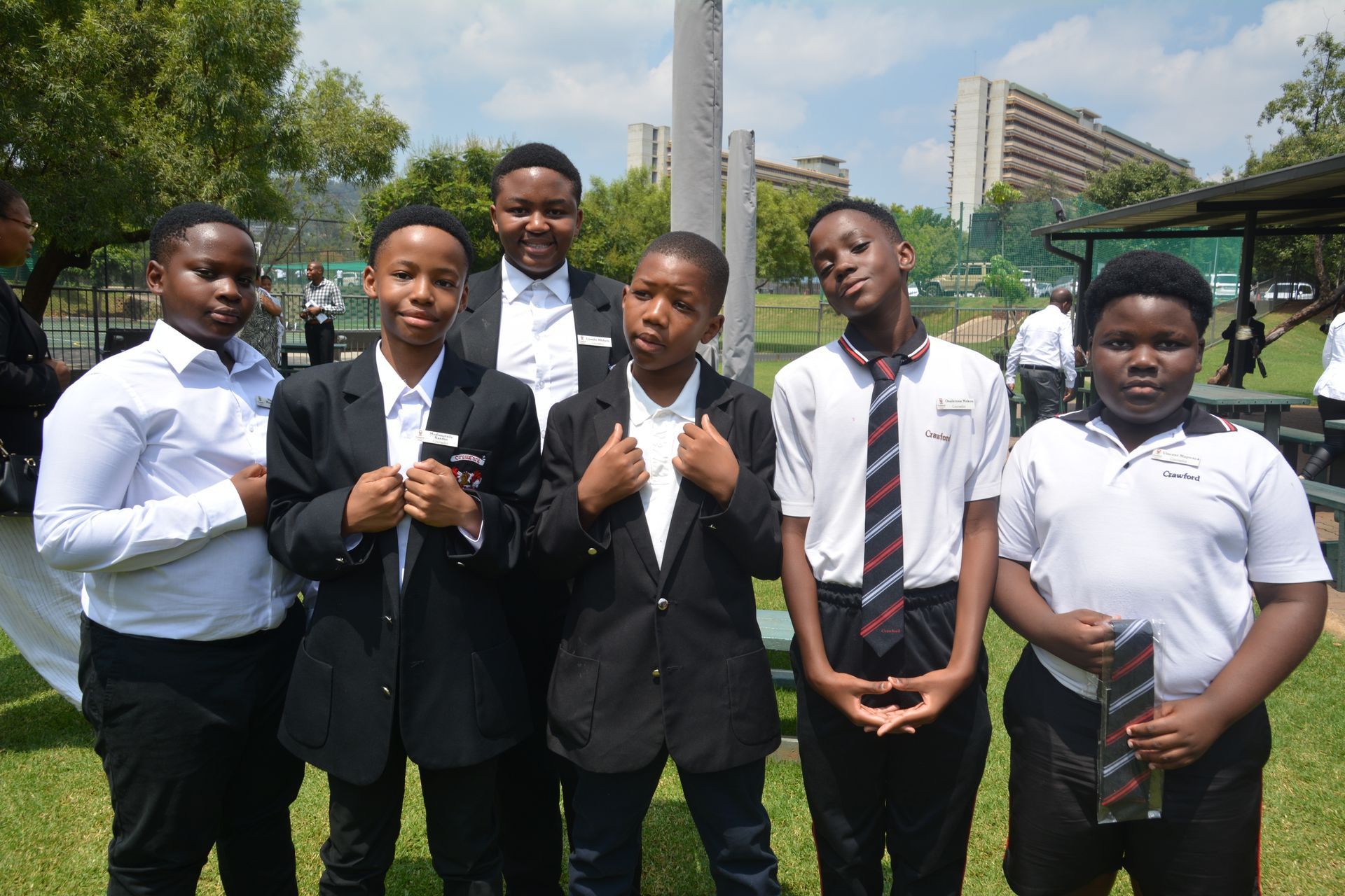 A group of young men in suits and ties are posing for a picture.
