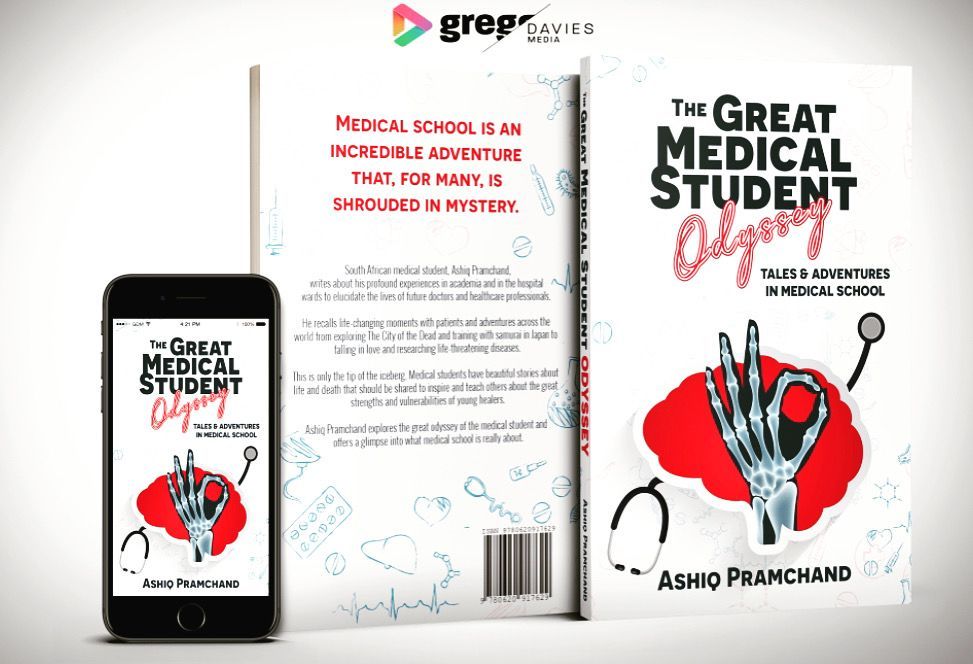 A book called the great medical student odyssey is sitting next to a cell phone.