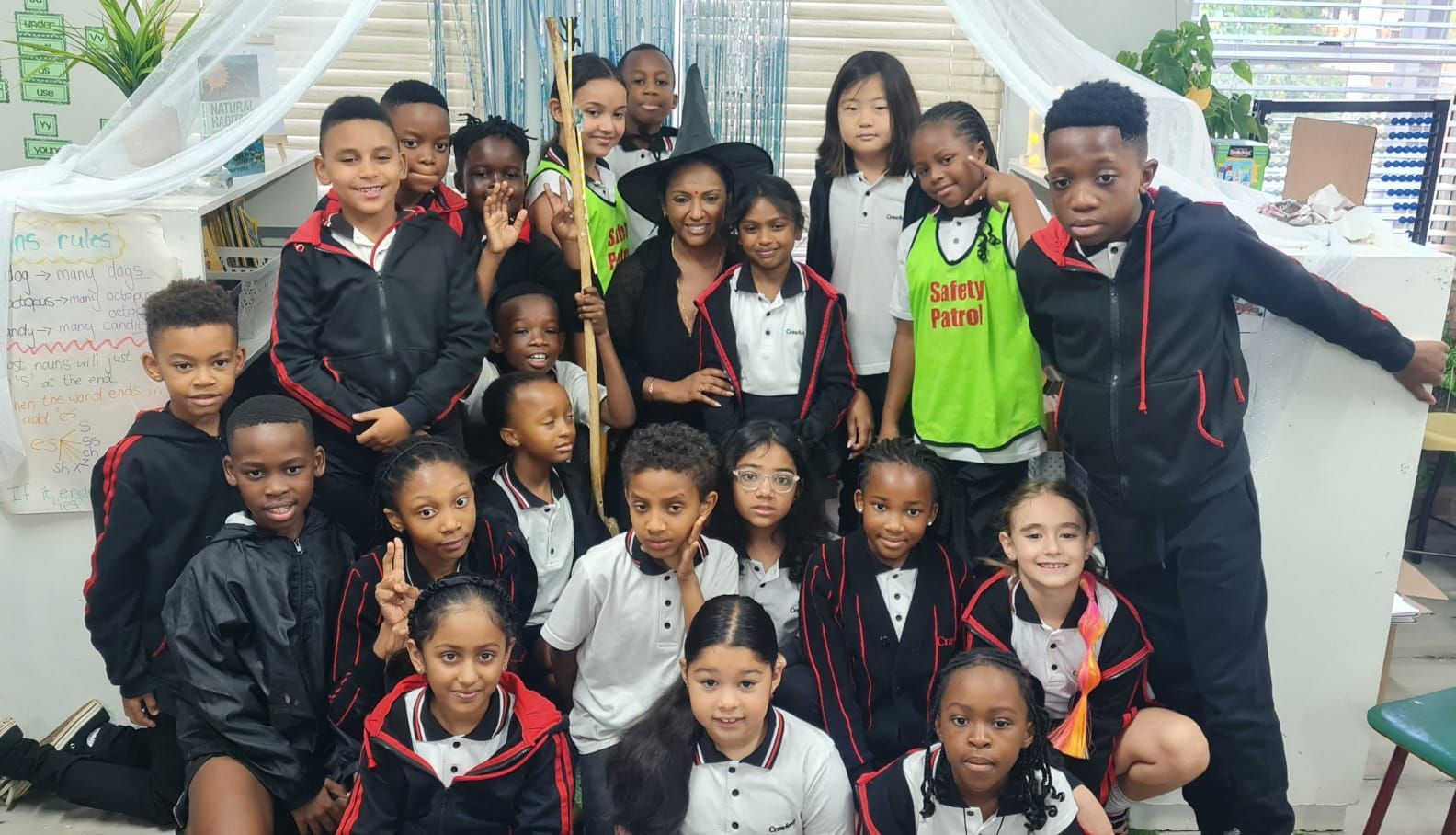 A group of children are posing for a picture in a classroom.