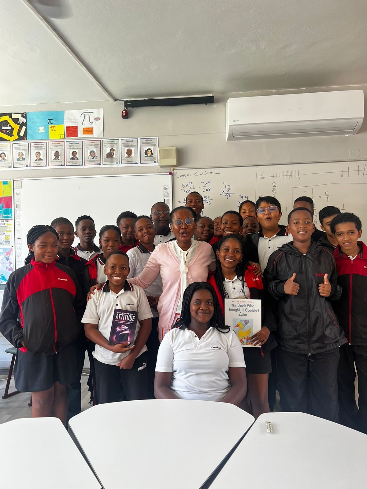A group of people are posing for a picture in a classroom.