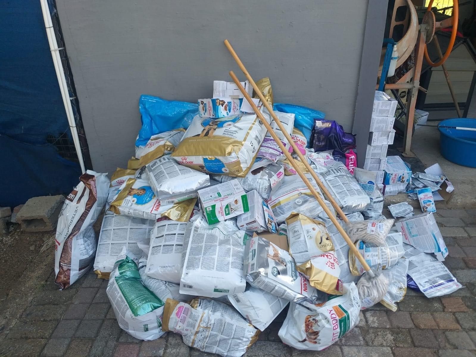 A pile of trash is sitting on the sidewalk in front of a building.