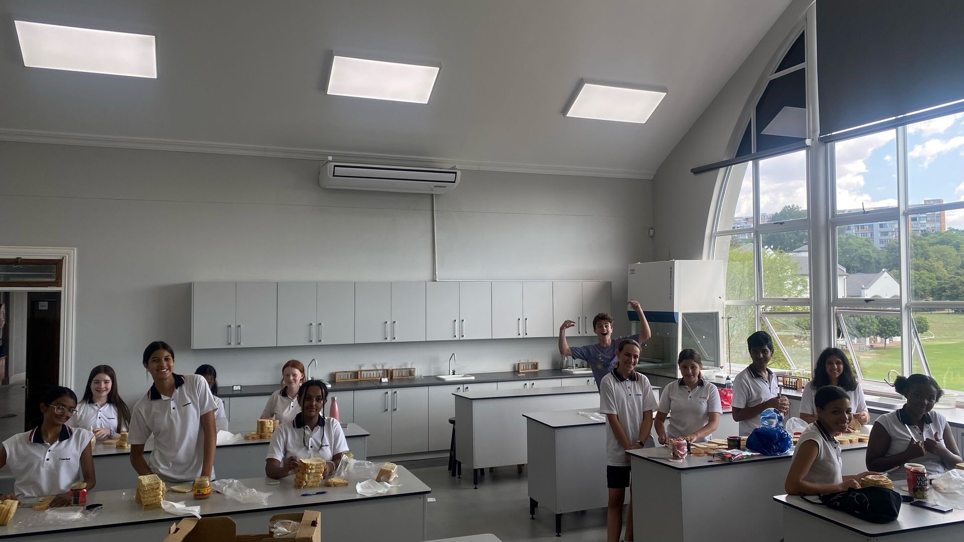 A group of children are sitting at tables in a classroom.