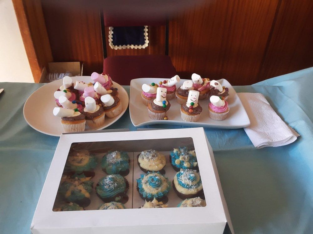 Three plates of cupcakes and a box of cupcakes on a table