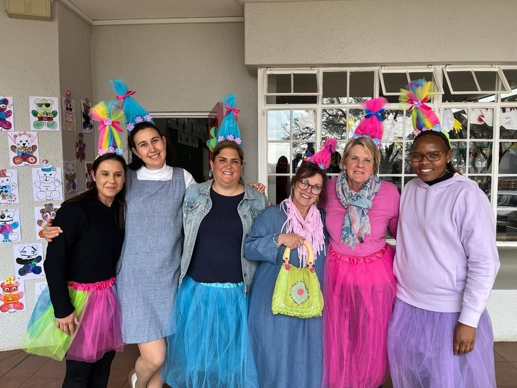 A group of women dressed as trolls are posing for a picture.