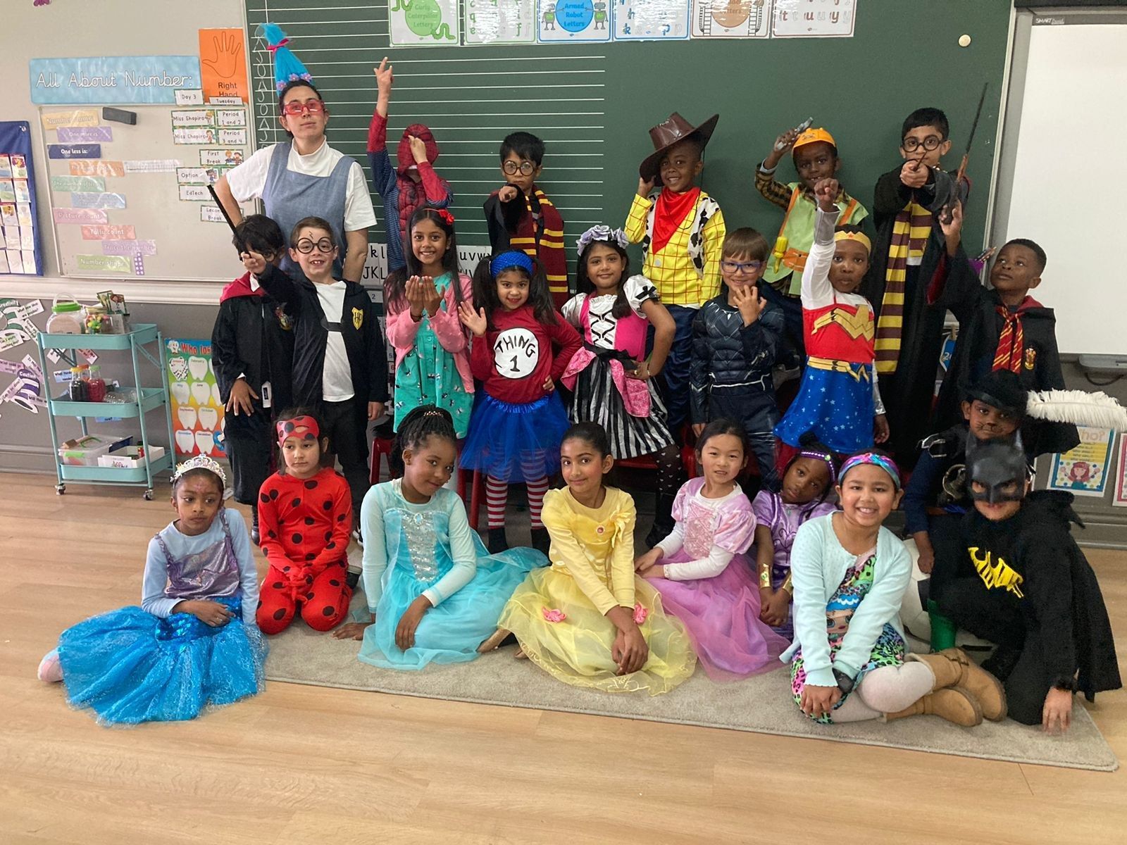 A group of children dressed in costumes are posing for a picture in a classroom.
