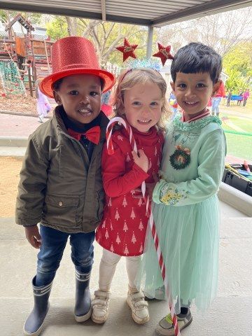 Three children are dressed up in christmas costumes and posing for a picture.