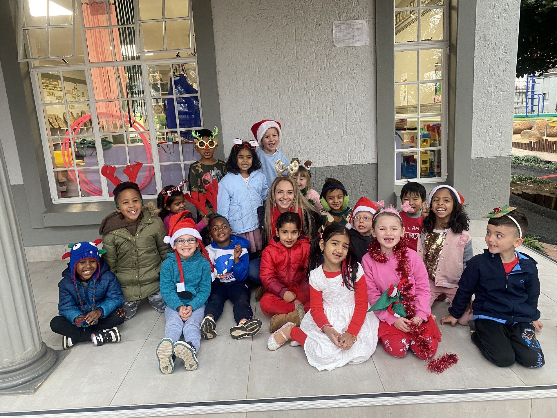 A group of children wearing santa hats are posing for a picture.