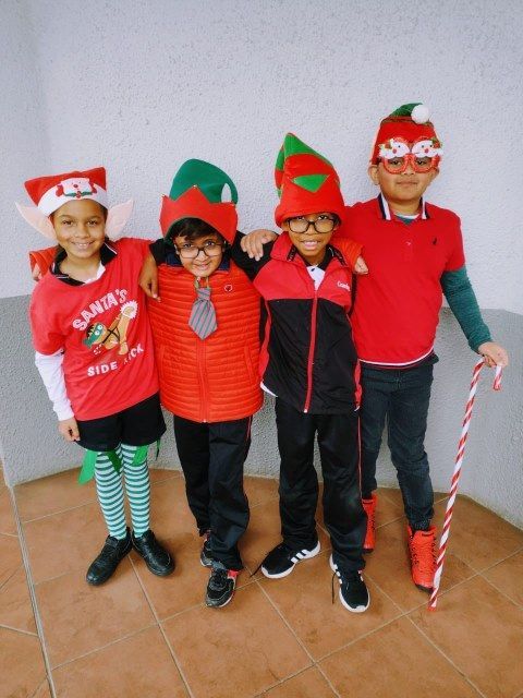 A boy wearing a shirt that says santa 's helper