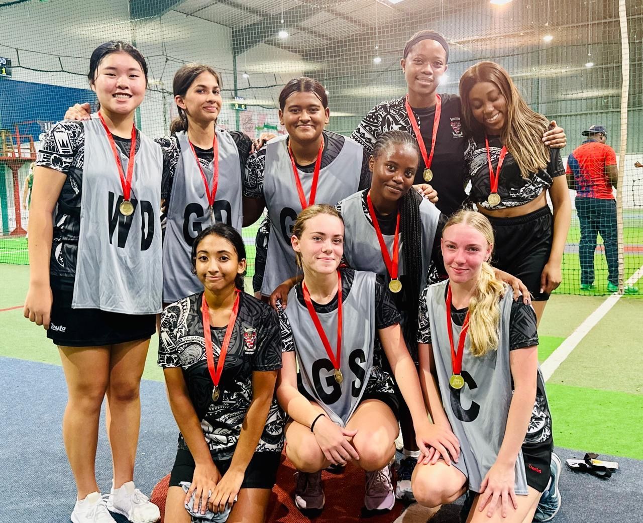 A group of young girls wearing medals are posing for a picture.