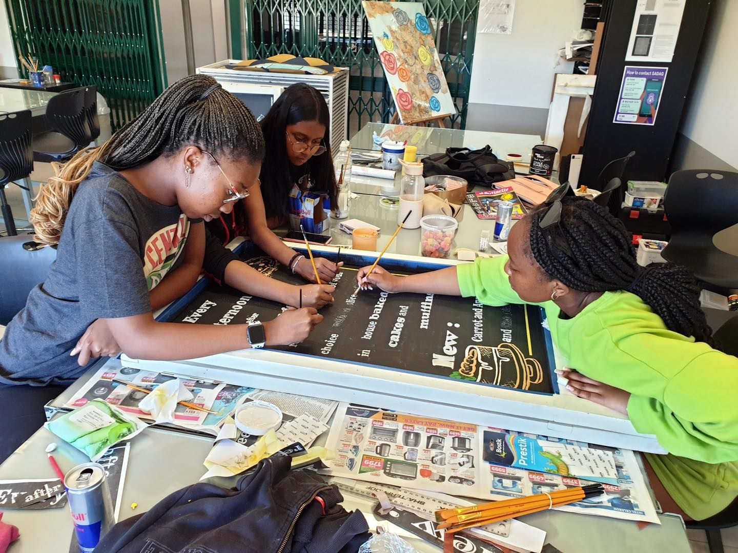 A group of young girls are sitting around a table painting.