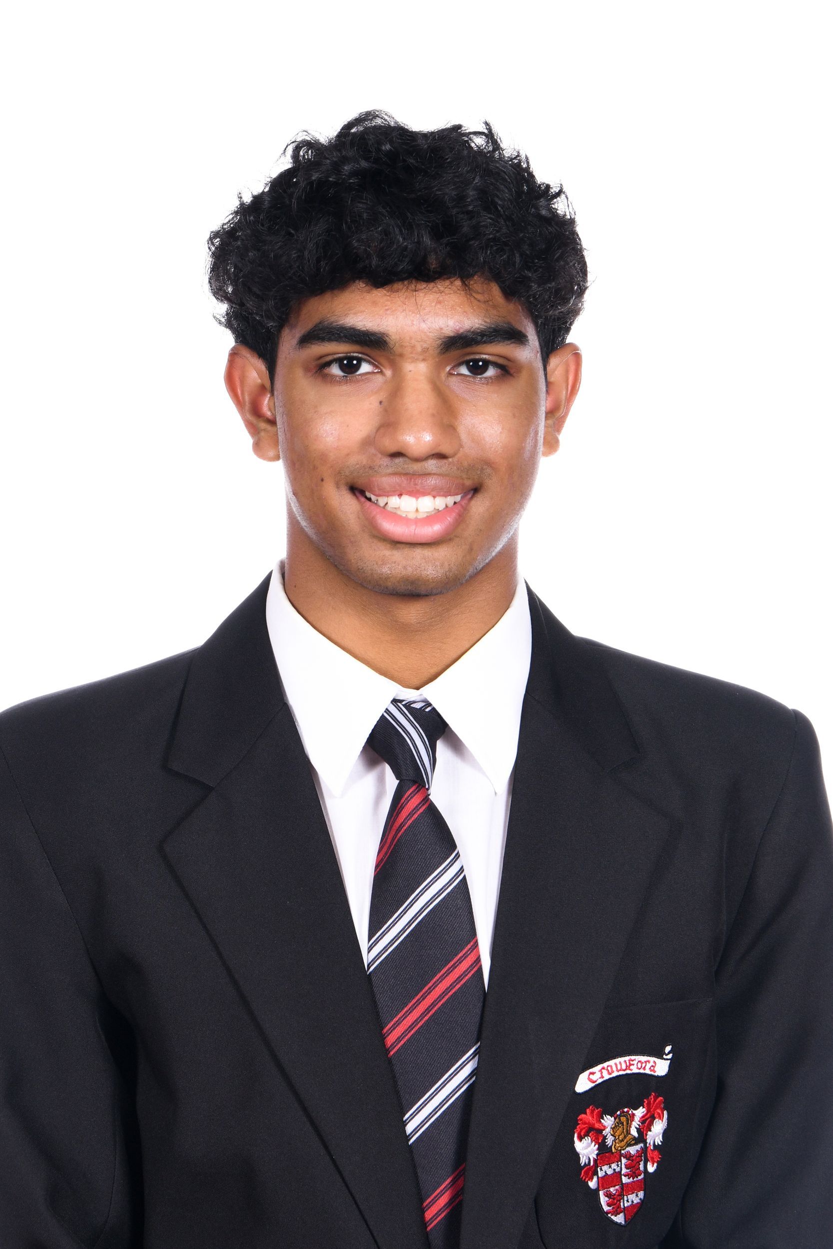 A young man in a suit and tie is smiling for the camera