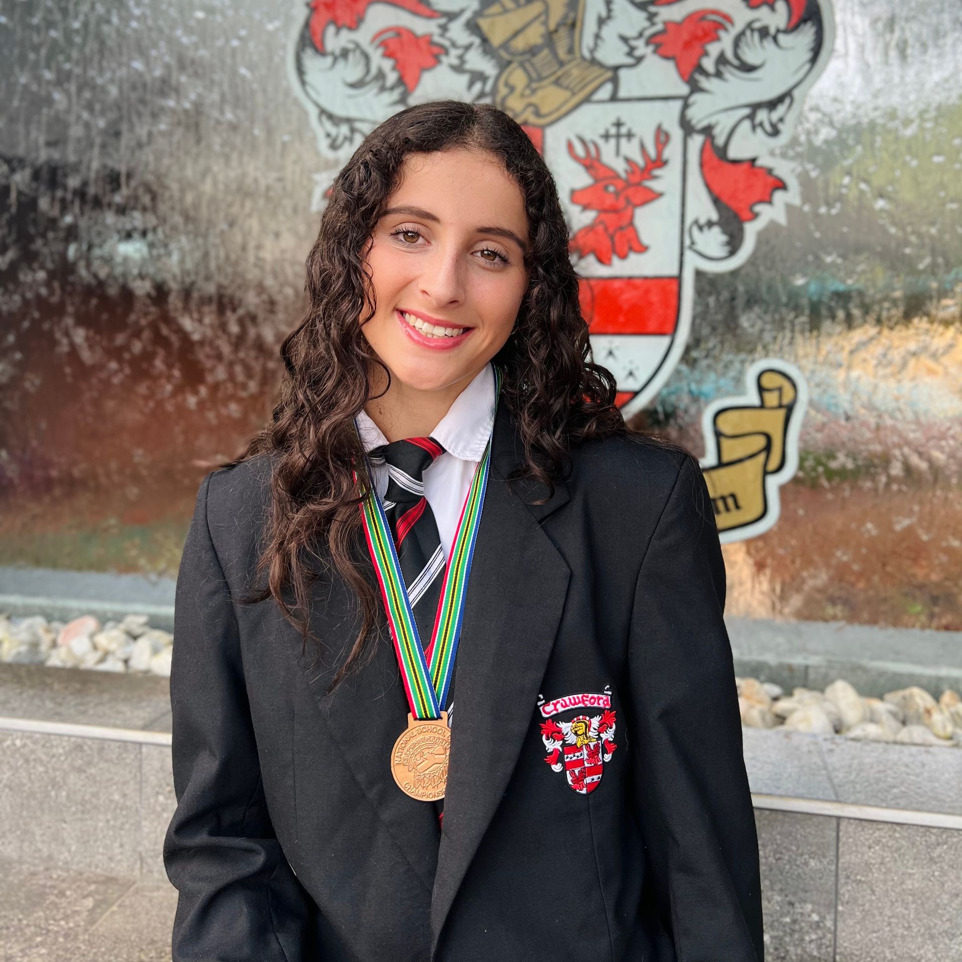 A woman in a school uniform with a medal around her neck