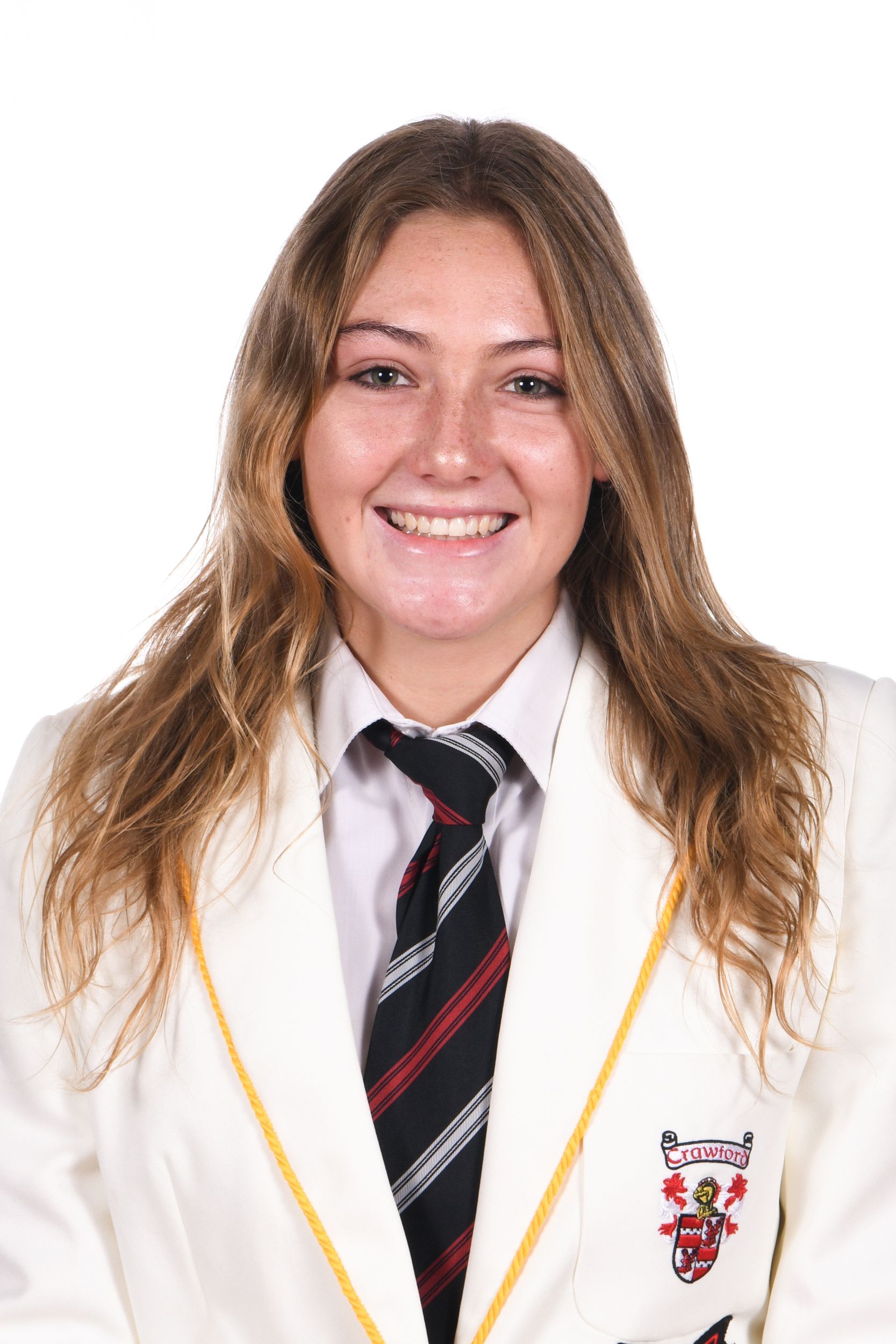 Woman in a white blazer and tie smiling at the camera.