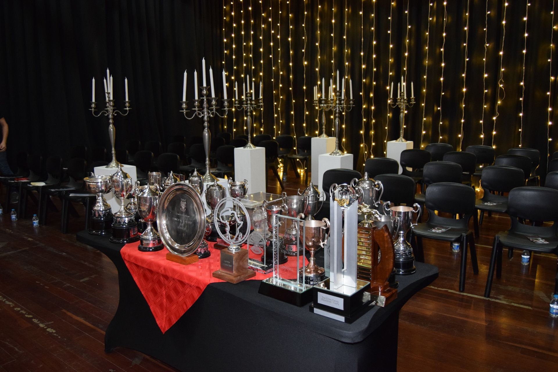 A table with trophies and candles on it in a room.