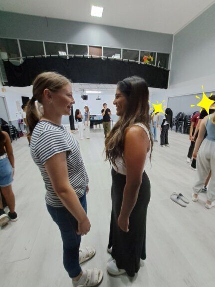 Two women are standing next to each other in a dance studio