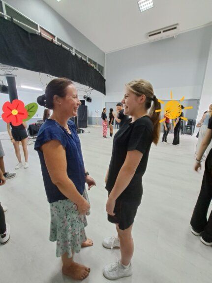 Two women are standing next to each other in a dance studio.