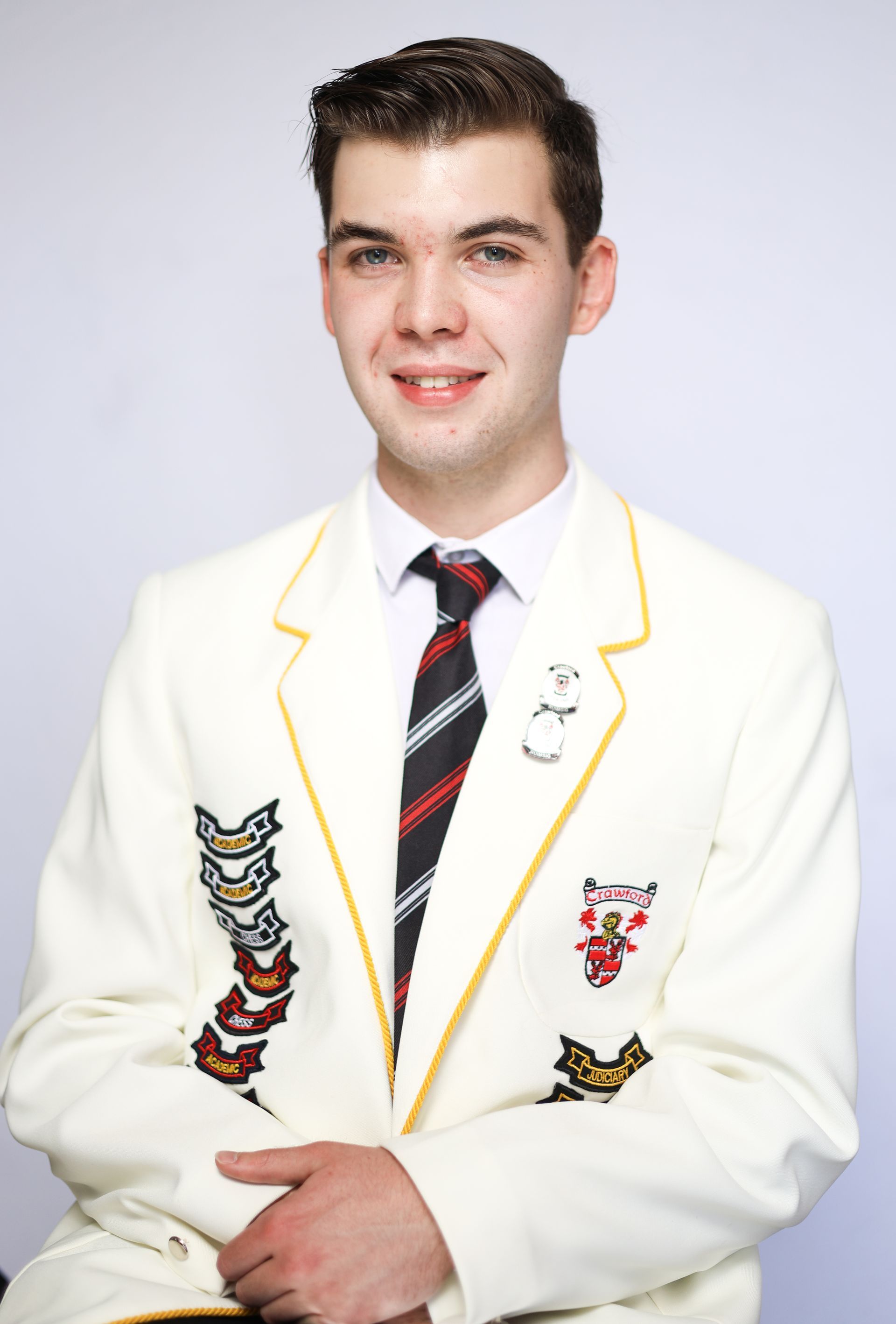 A young man is wearing a white jacket and tie