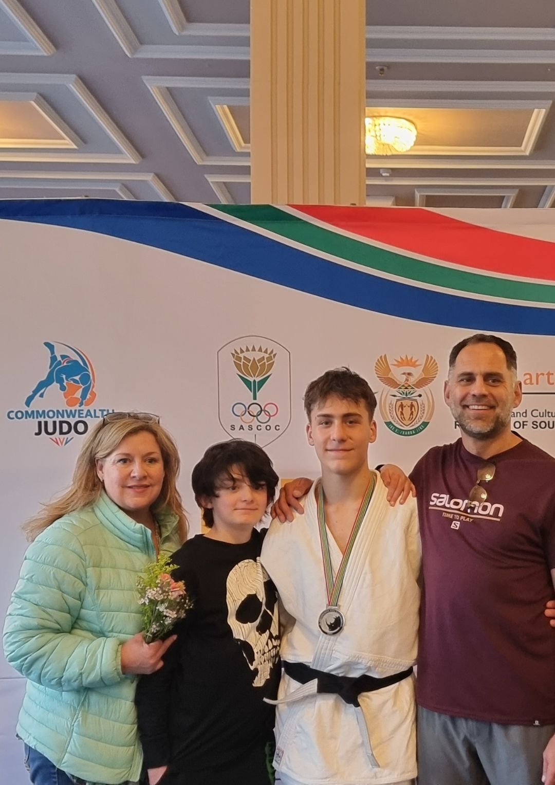 A family posing for a picture with a boy wearing a medal.