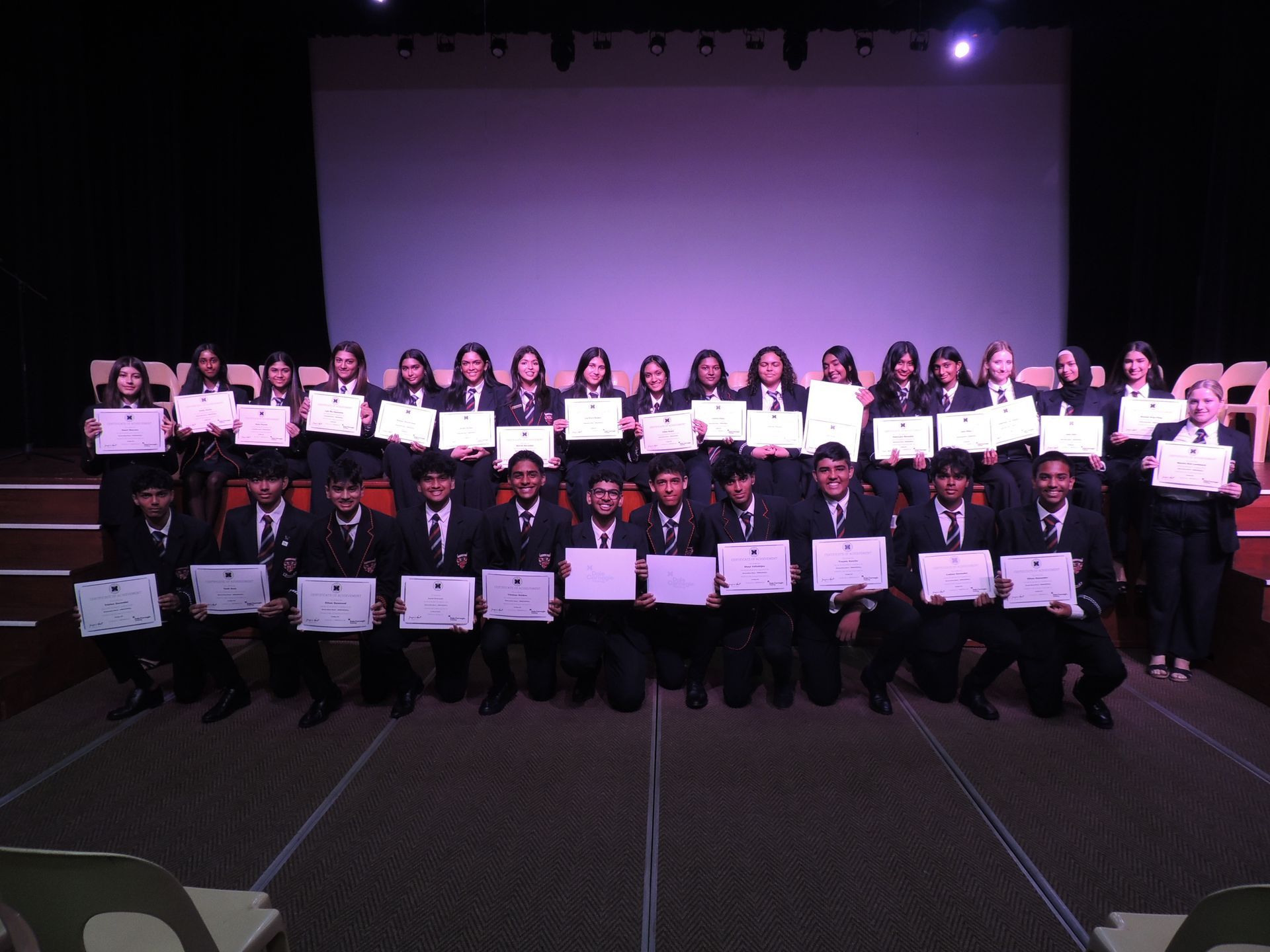 A group of people posing for a picture holding certificates