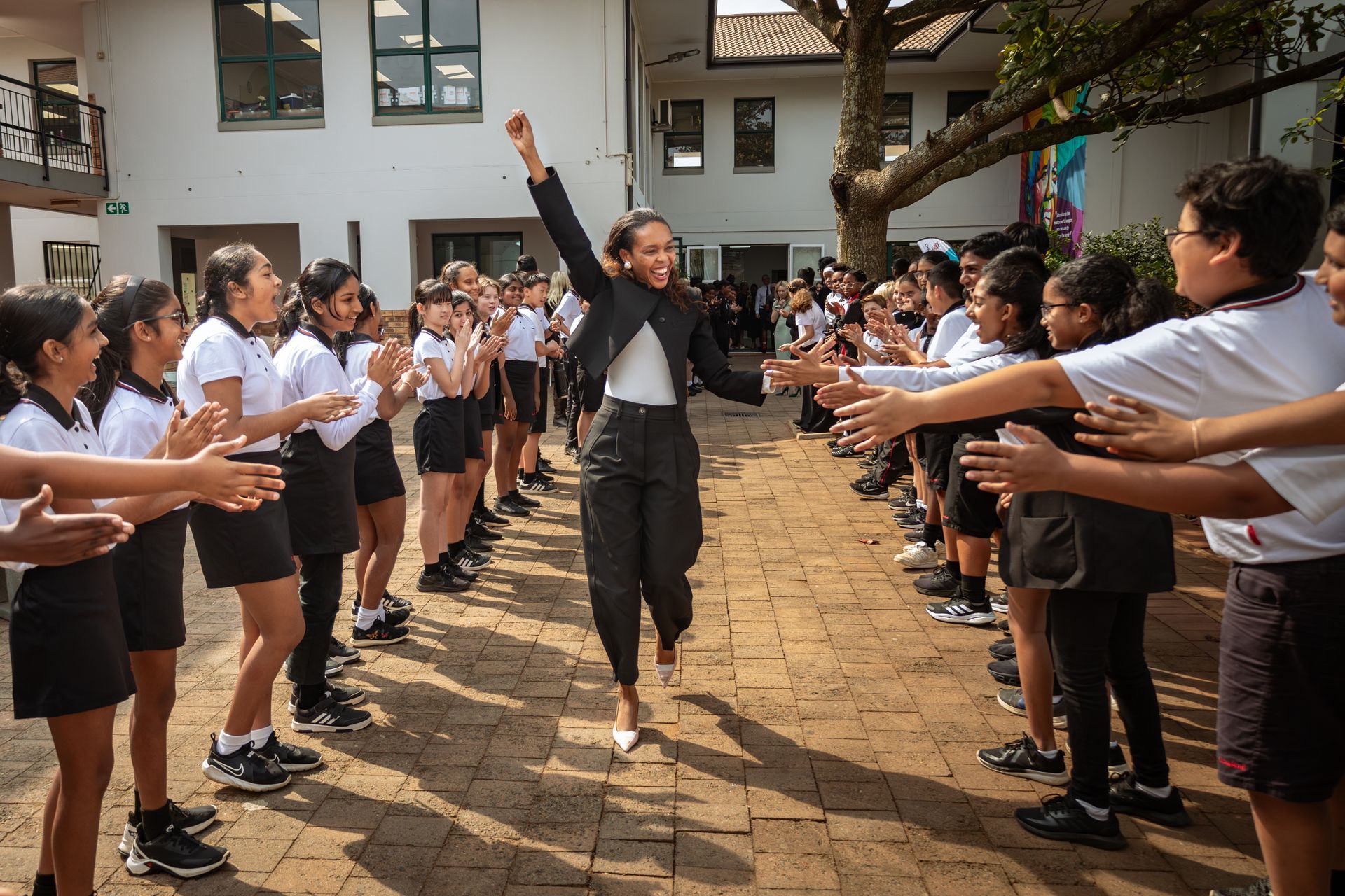 A woman is standing in front of a group of children.