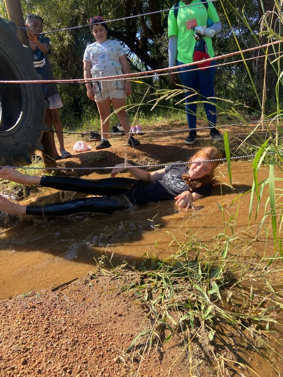 Little girl lying in muddy water