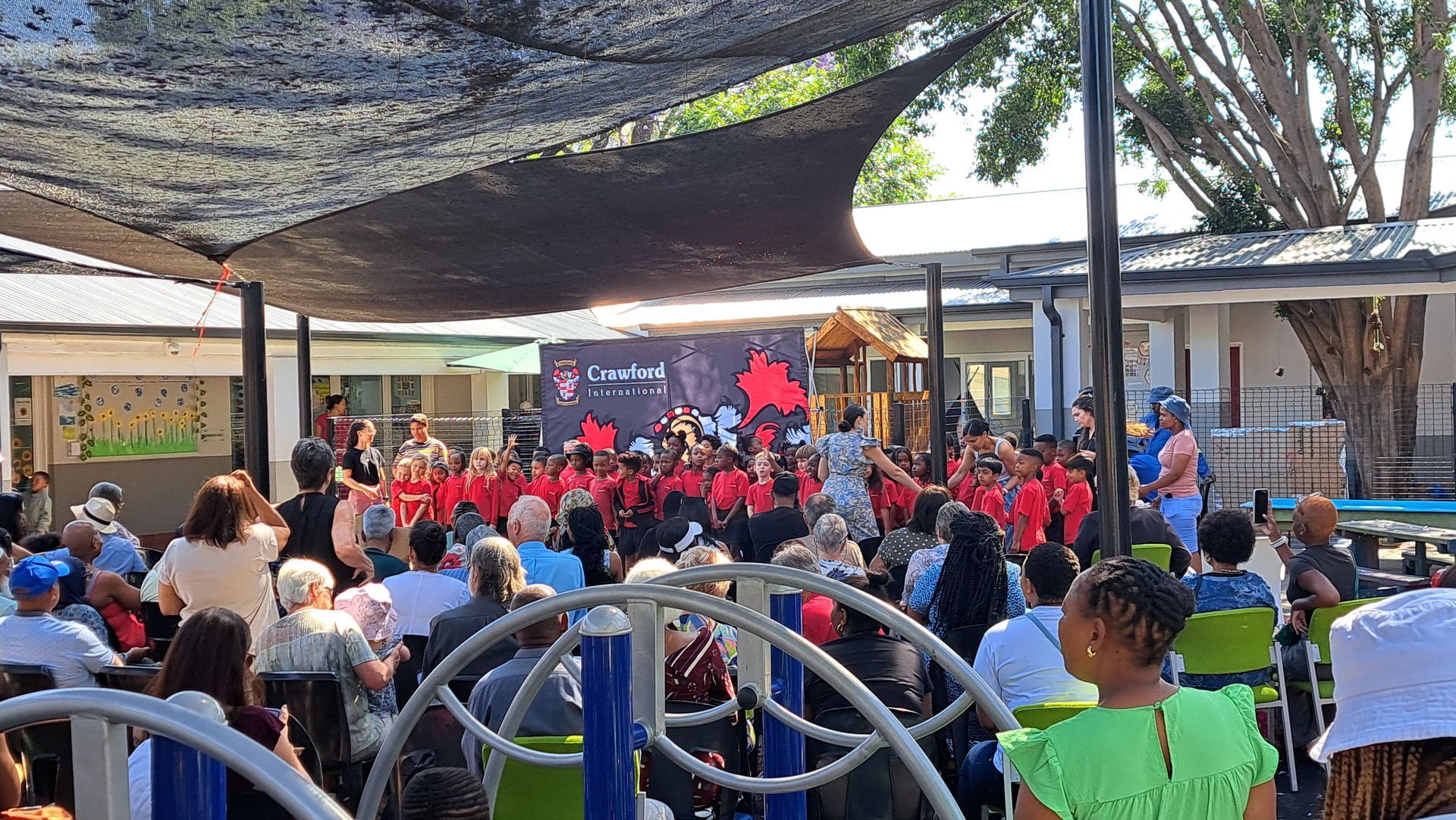 A large group of people are sitting in front of a stage.
