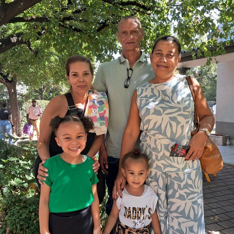 A family posing for a picture with one girl wearing a shirt that says daddy 's